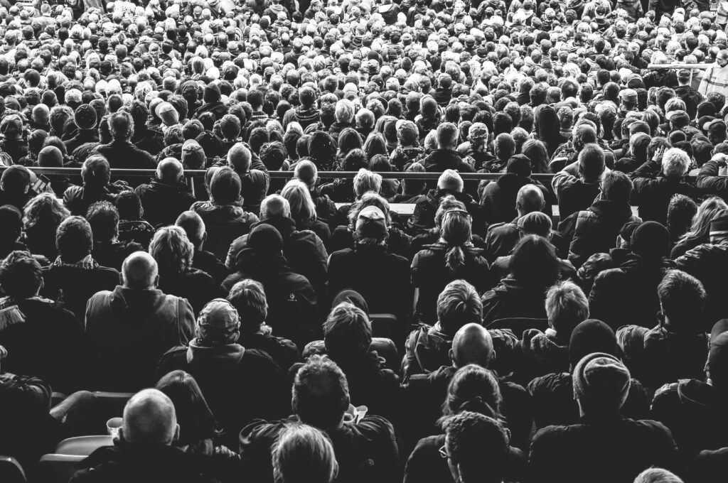 black and white picture of a large crowd of people at a stadium.