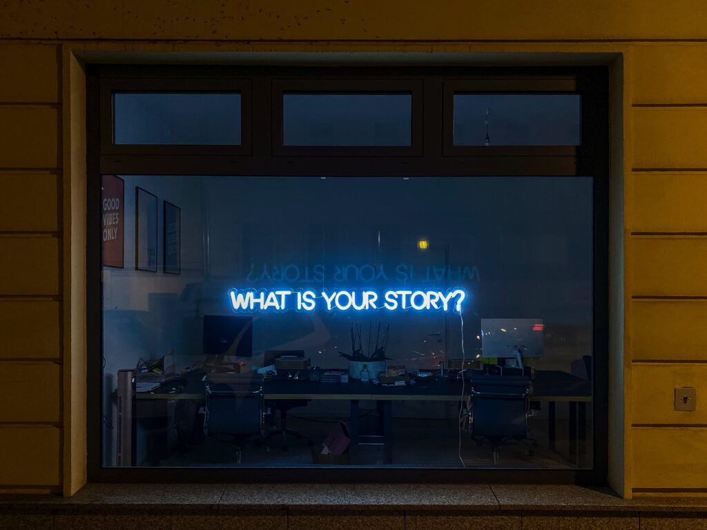 A shop window with a blue LED light that reads: "What is Your Story?"