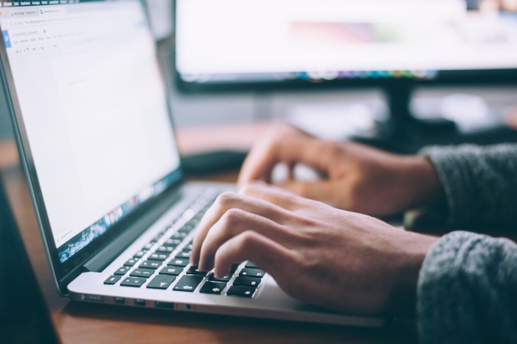 A person typing on a mac laptop.