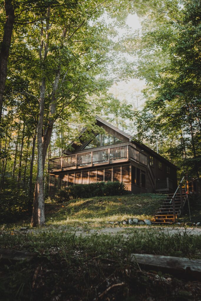 Wooden cabin house in the woods. There is a wooden balcony.